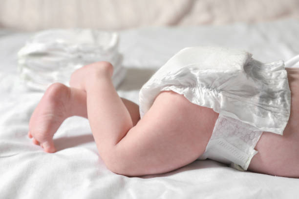 istock Little baby in diaper lying on bed, closeup 1489126170