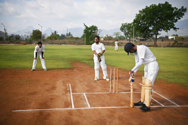 istock Cricket batsman on the field, warming up and wicket keeper adjusting his gloves getting ready before the ball delivery 1489128406