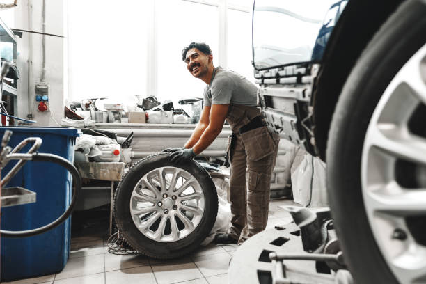 istock Mechanic pushing a car tire in car service 1489131381