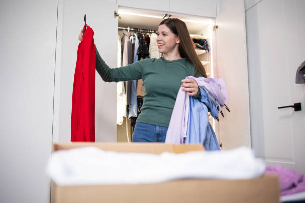 istock A woman sorts through her wardrobe, decluttering 1489133278