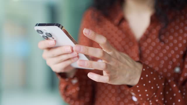 Close up of woman's hands holding smartphone, female running fingers on touch screen, using phone, reading text message
