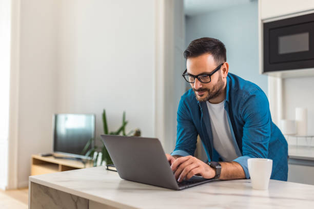 istock Focused man working over the laptop, leaning on a desk, with glasses on. 1489136425