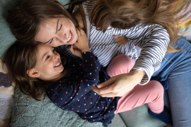 istock Mother cuddling with her daughters at home 1489136795