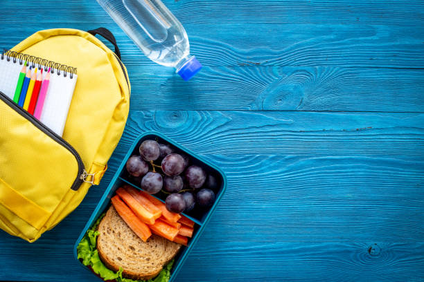 istock Healthy school lunch box with fruits and backpack, top view 1489138407
