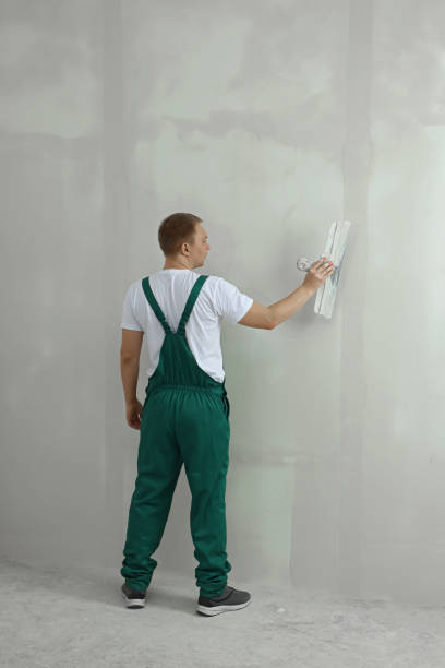 istock Professional worker plastering wall with putty knife indoors 1489139471