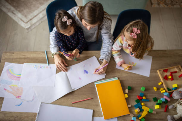 istock Mother drawing with her two daughters at home 1489141972