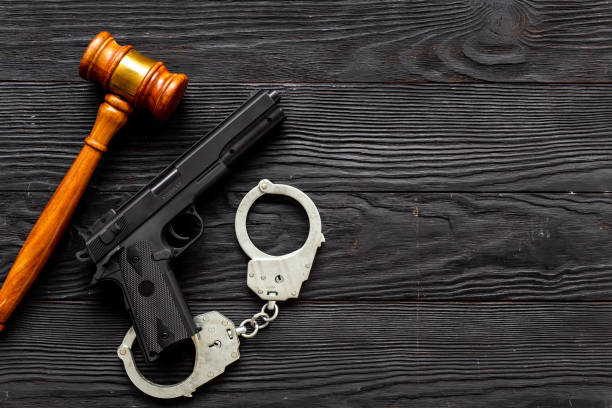 istock Hand gun weapon with handcuffs - illegal use of weapons concept 1489142820