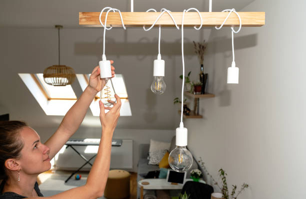 istock Young woman changing light bulbs at home. 1489143510
