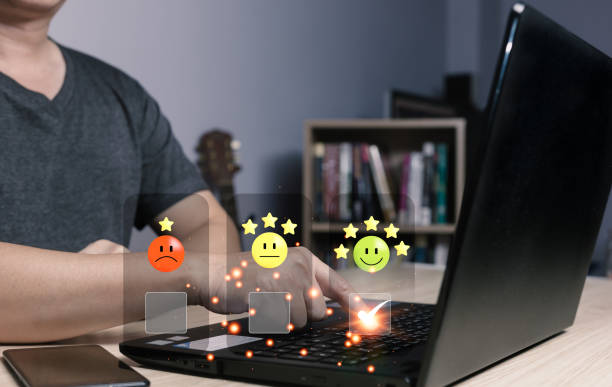 istock a businessman using computer laptop and touching the virtual screen on the happy smile face icon to give satisfaction in service. rating very impressed. Customer service and Satisfaction concept 1489145219