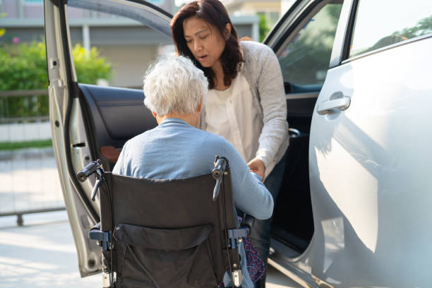 Caregiver help and support asian elderly woman sitting on wheelchair prepare get to her car to travel in holiday. Caregiver help and support asian elderly woman sitting on wheelchair prepare get to her car to travel in holiday. senior adult car nurse physical impairment stock pictures, royalty-free photos & images