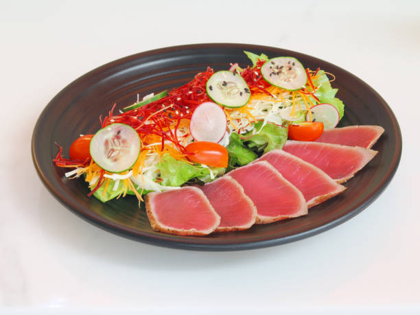 thunfisch-salat. japanischer traditioneller salat mit stücken von medium-rare gegrillt ahi thunfisch und sesam mit frischem gemüse in eine schüssel geben. authentische japanische küche. ansicht von oben - tuna prepared ahi tuna steak seared stock-fotos und bilder