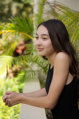 A young Hawaiian teen adolescent girl in her home, looking away