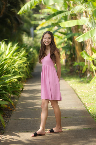 A young Hawaiian teen adolescent girl outdoor, looking at camera, smiling.