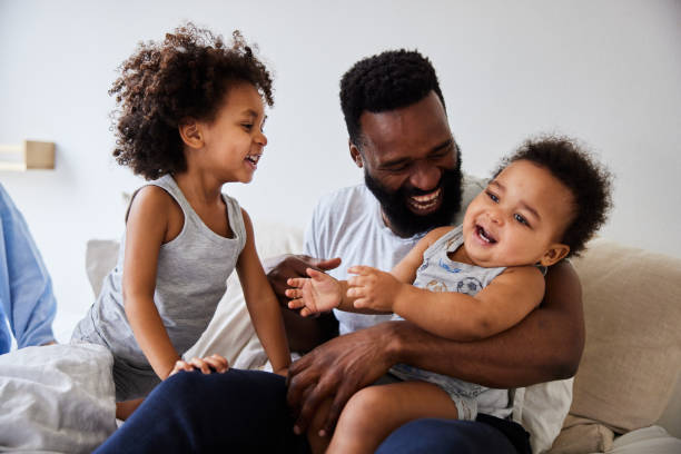 istock Dad playing with his young sons while sitting with his wife in bed 1489153497