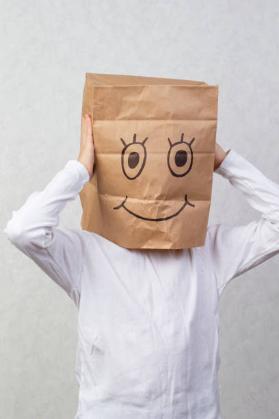 istock The boy has a cardboard box above his head with a funny smiley face drawn on it. 1489155480