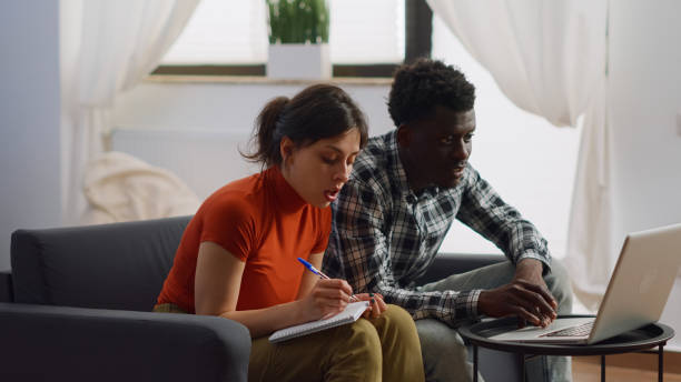 istock Interracial couple doing taxes payment using laptop 1489157419