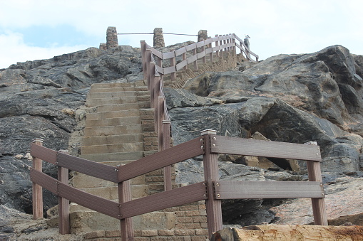 Stone architecture with a wooden ladder at Shravanabelagola, signaling historical cultural heritage.