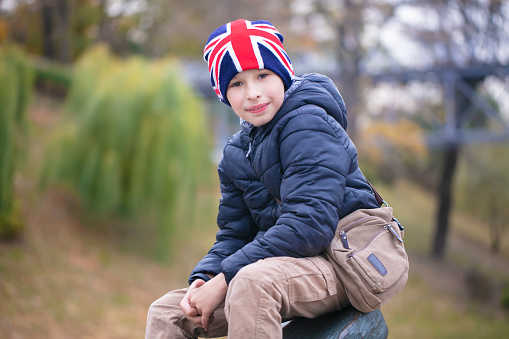A happy child in a British flag hat looks at the camera.