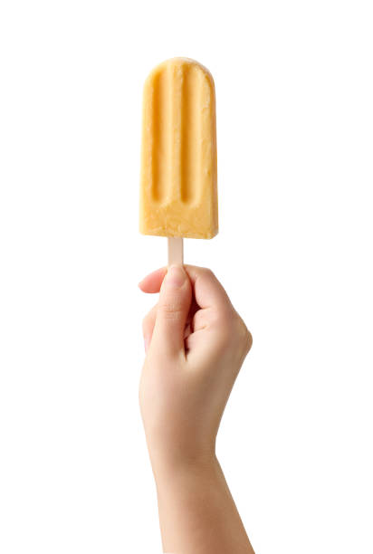 istock Woman hand holding yellow fruit popsicle on white background 1489160322