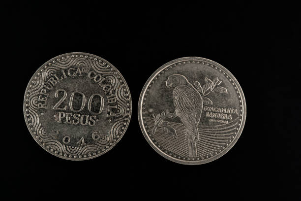 200 Colombian pesos coins on a black background close-up