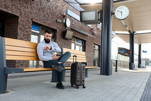 Mid adult businessman traveling at a railway station. About 30 years old, Caucasian male.