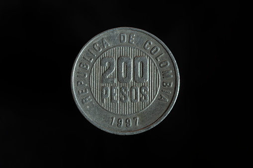 200 Colombian pesos coins on a black background close-up
