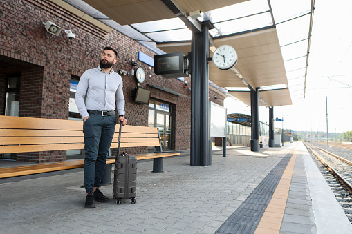 Mid adult businessman traveling at a railway station. About 30 years old, Caucasian male.