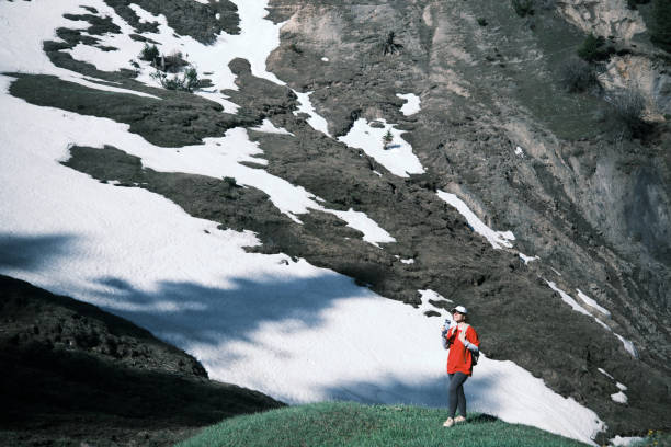 Female hiker is drinking water in mountains