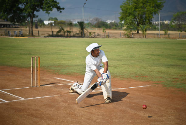In this photo, a skilled batsman showcases his technique by executing a dynamic sweep shot during an intense cricket match. The image captures the essence of the game, as the batsman elegantly maneuvers his body to connect with the ball. With focused determination, he lowers himself and employs a sweeping motion, aiming to send the ball soaring towards the desired direction. The batsman's stance exudes confidence and expertise. This photo perfectly encapsulates the excitement and skill involved in playing a sweep shot.