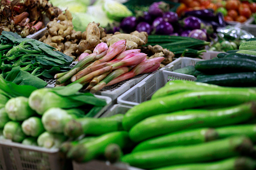 Green vegetables and various herb and spice items are available for sale at the farmer's market, emphasizing the concepts of healthy eating, vegetarianism, and veganism.