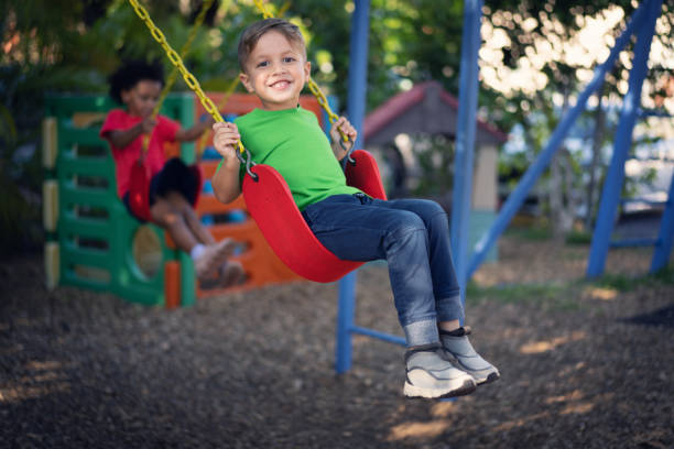 istock Cheerful boy having fun as he swing on the playground 1489170387