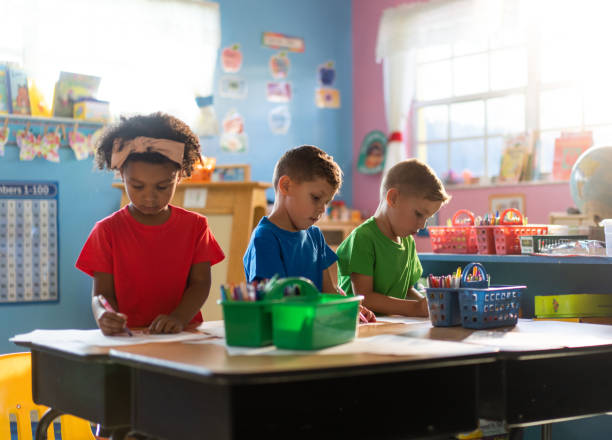 istock Three preschool kids coloring at a daycare school 1489170512