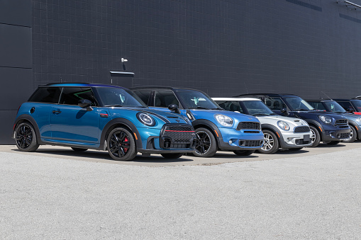 Oakville, Ontario, Canada- September 18, 2022.  MINI COOPER cars at the public parking lot in the shopping mall. Mini car has been around since 1959 and has been owned and issued by various car manufacturers.