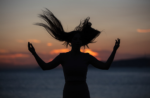 Silhouette of young woman at sunset.