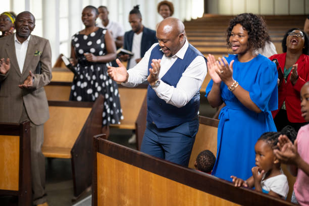 Multi-generation family dancing and singing in church Multi-generation family and congregation enjoying church service black gospel church stock pictures, royalty-free photos & images