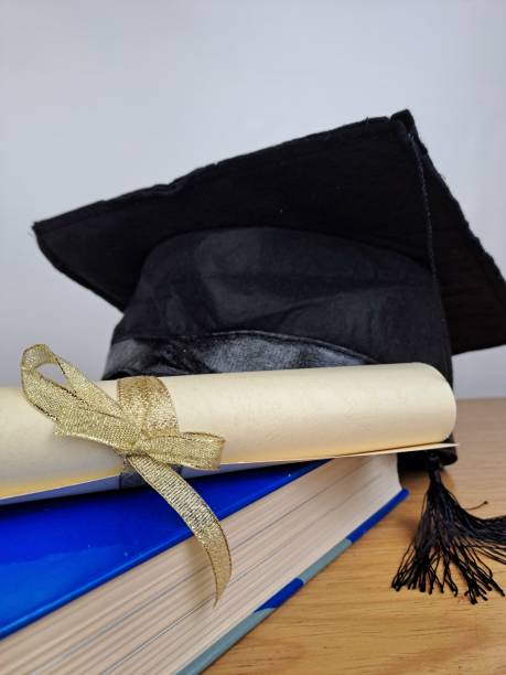 istock Graduation hat with degree paper on a stack of books 1489176837