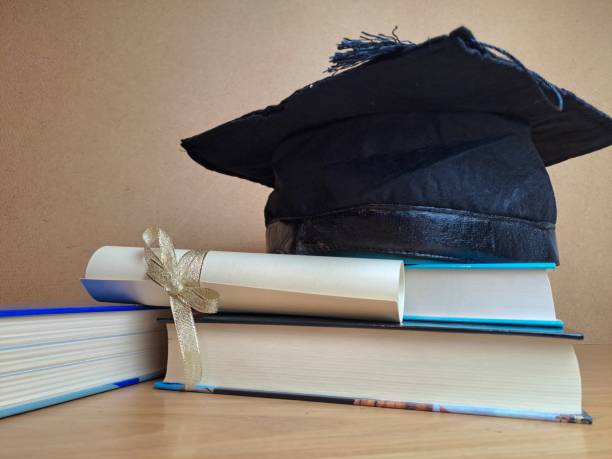 istock Graduation hat with degree paper on a stack of books 1489176839