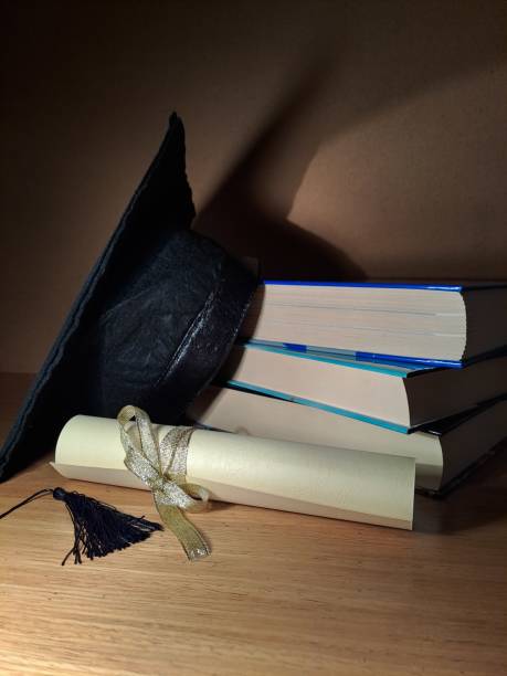 istock Graduation hat with degree paper on a stack of books 1489176864