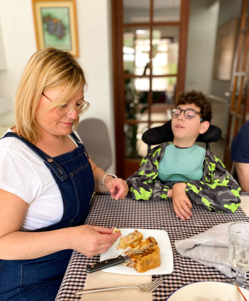 istock Mom feeding her son with cerebral palsy 1489177818