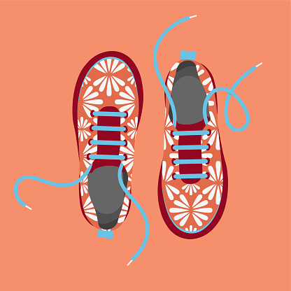 A pair of fashionable shoes with abstract floral ornament and untied laces. View from above.