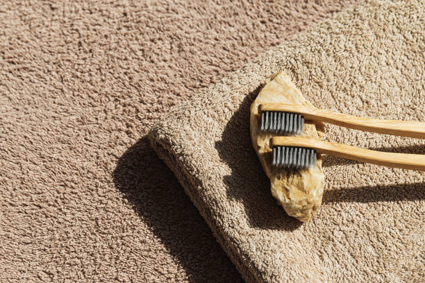 istock Creative layout made of two toothbrushes on beige towel sunlit background . Morning routine concept. Minimal style 1489182655