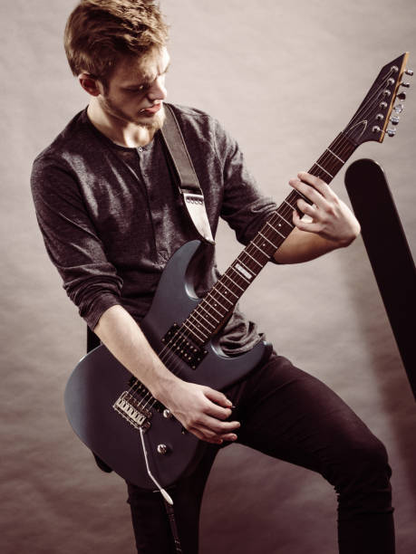 istock Young man playing electric guitar 1489182952