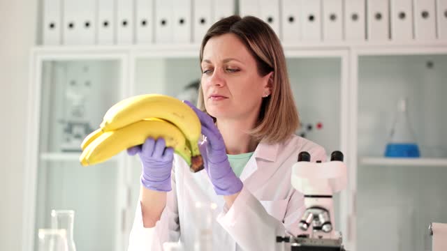 Scientist in laboratory is studying bananas closeup