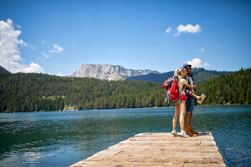 Happy young couple relax at  lake.Holiday, travel and hiking concept