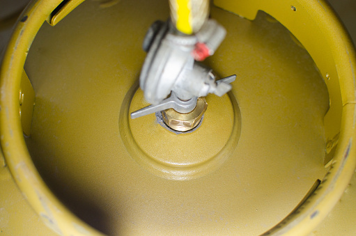 Cooking gas. Photo of a kitchen gas cylinder connected to a gas regulator. LPG, butane, propane.