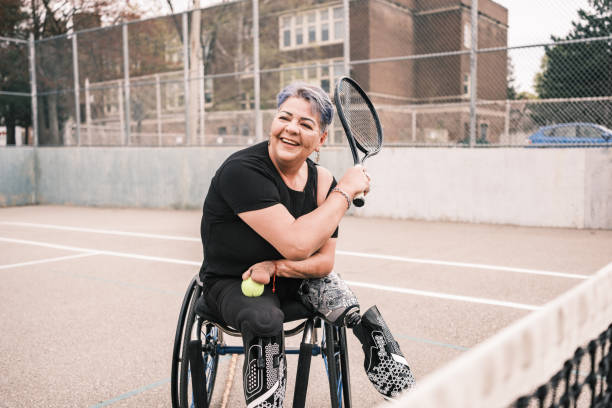 mujer latina discapacitada practica tenis en silla de ruedas al aire libre - wheelchair tennis physical impairment athlete fotografías e imágenes de stock