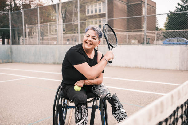 Disabled Latin woman practice wheelchair tennis outdoors stock photo
