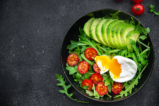 avocado salad poached egg, arugula, tomato, green salad leaves healthy meal food snack on the table copy space food background