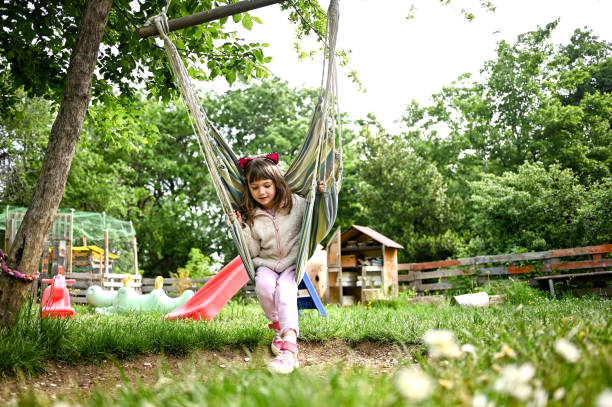 istock Cute preschool girl in a hammock on spring. 1489186783