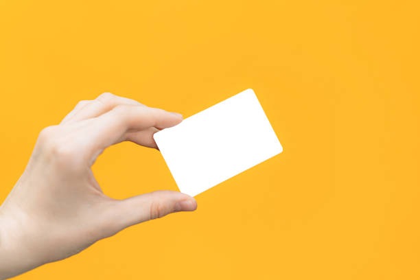 istock Blank white card in hand against yellow background 1489189378